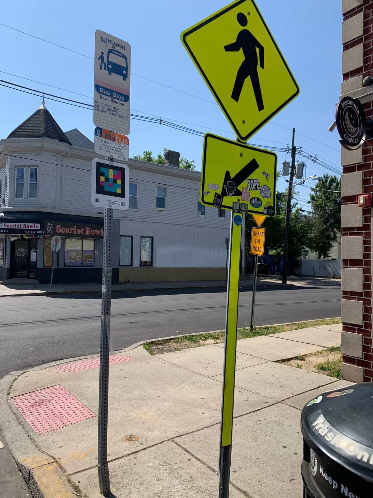 NJ TRANSIT mybus #23433 sign with NaviLens code on a corner next to Scarlet Bowls in the New Brunswick university corridor