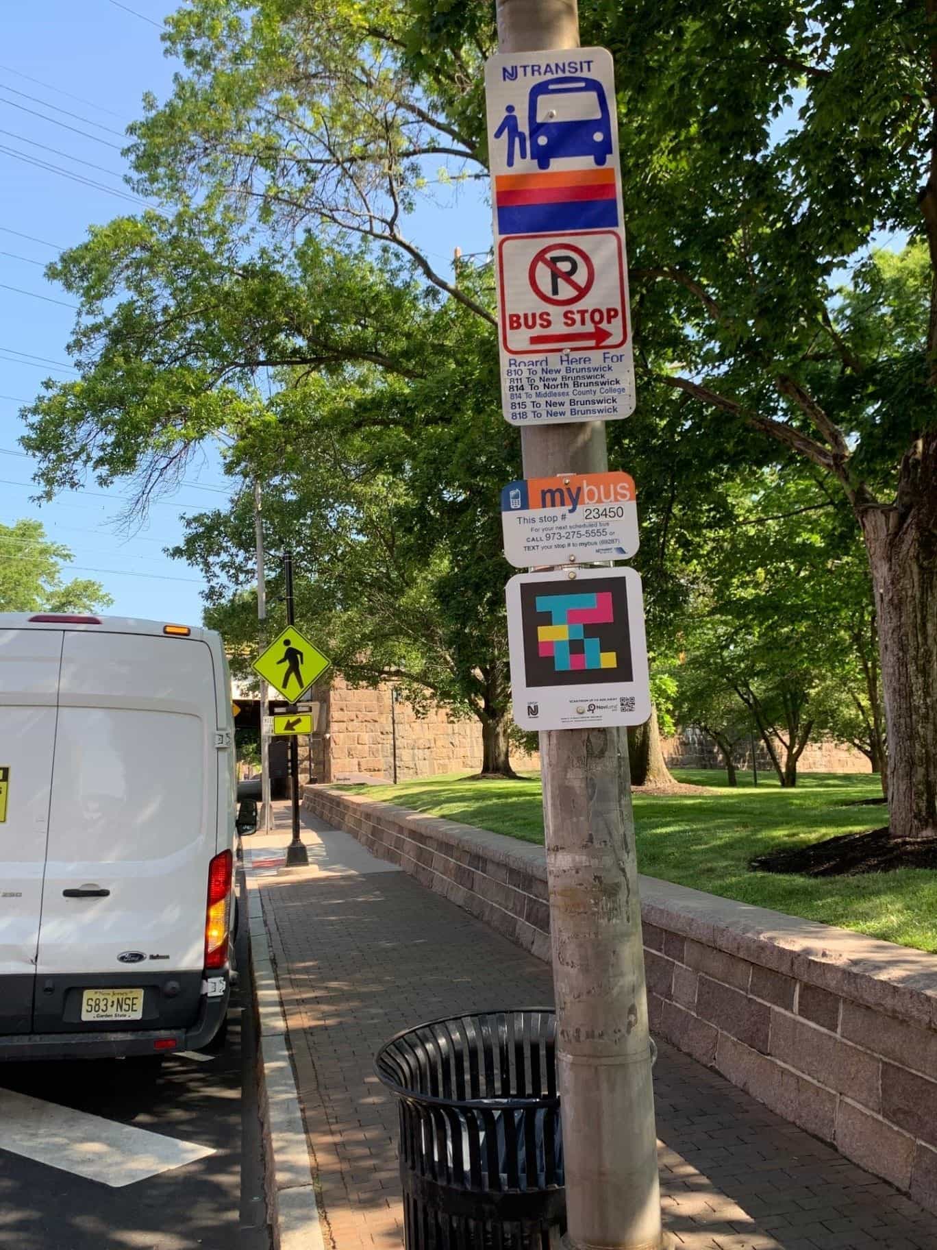 NJ TRANSIT-Maste mit mybus-Haltestellenschild Nr. 23450 und NaviLens-Code, neben dem Rutgers-Campus in New Brunswick (NJ)