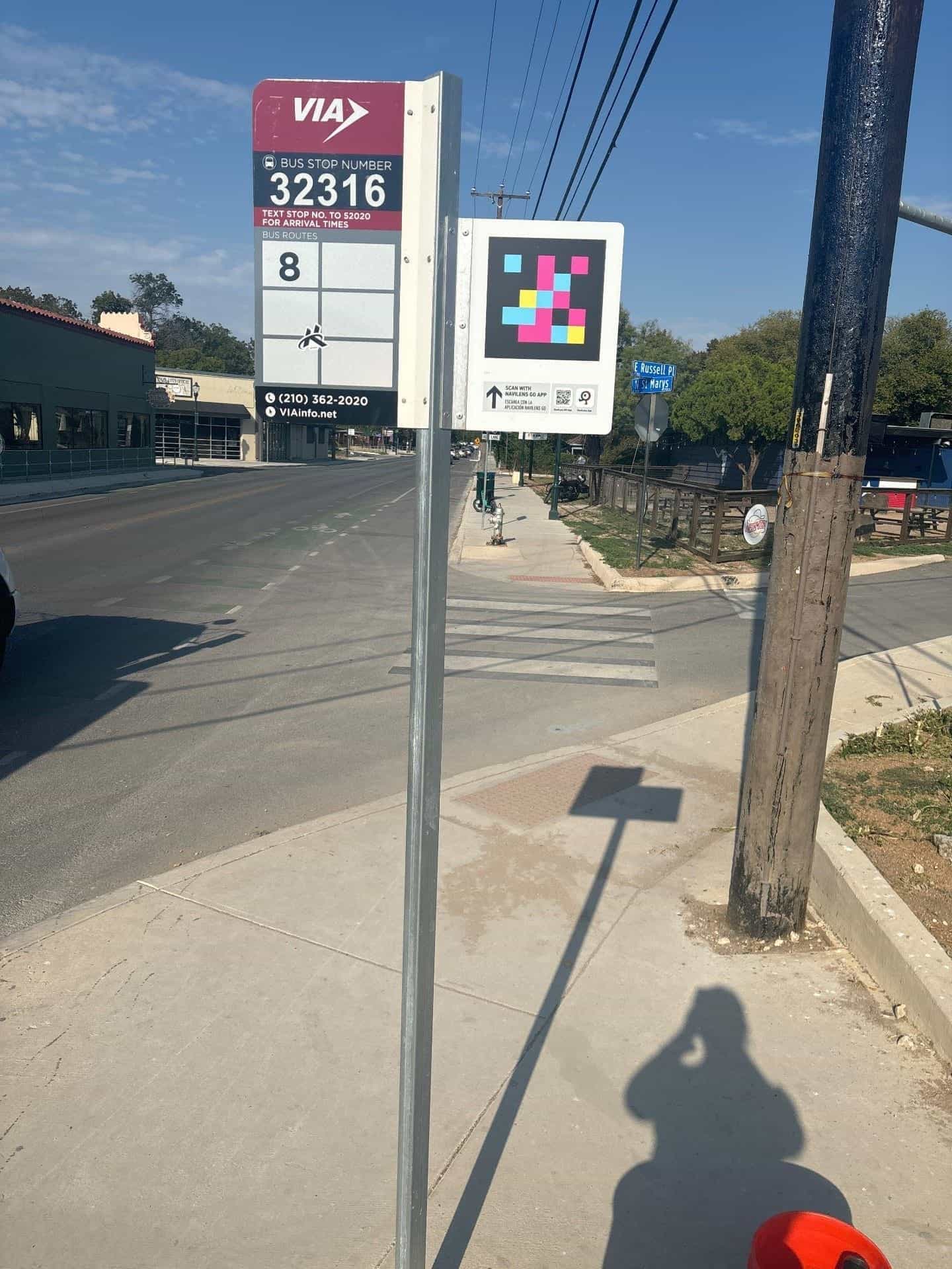 Mast der VIA San Antonio-Haltestelle 32316 mit großem NaviLens-Code neben dem roten Bus-Stop-Number-Schild