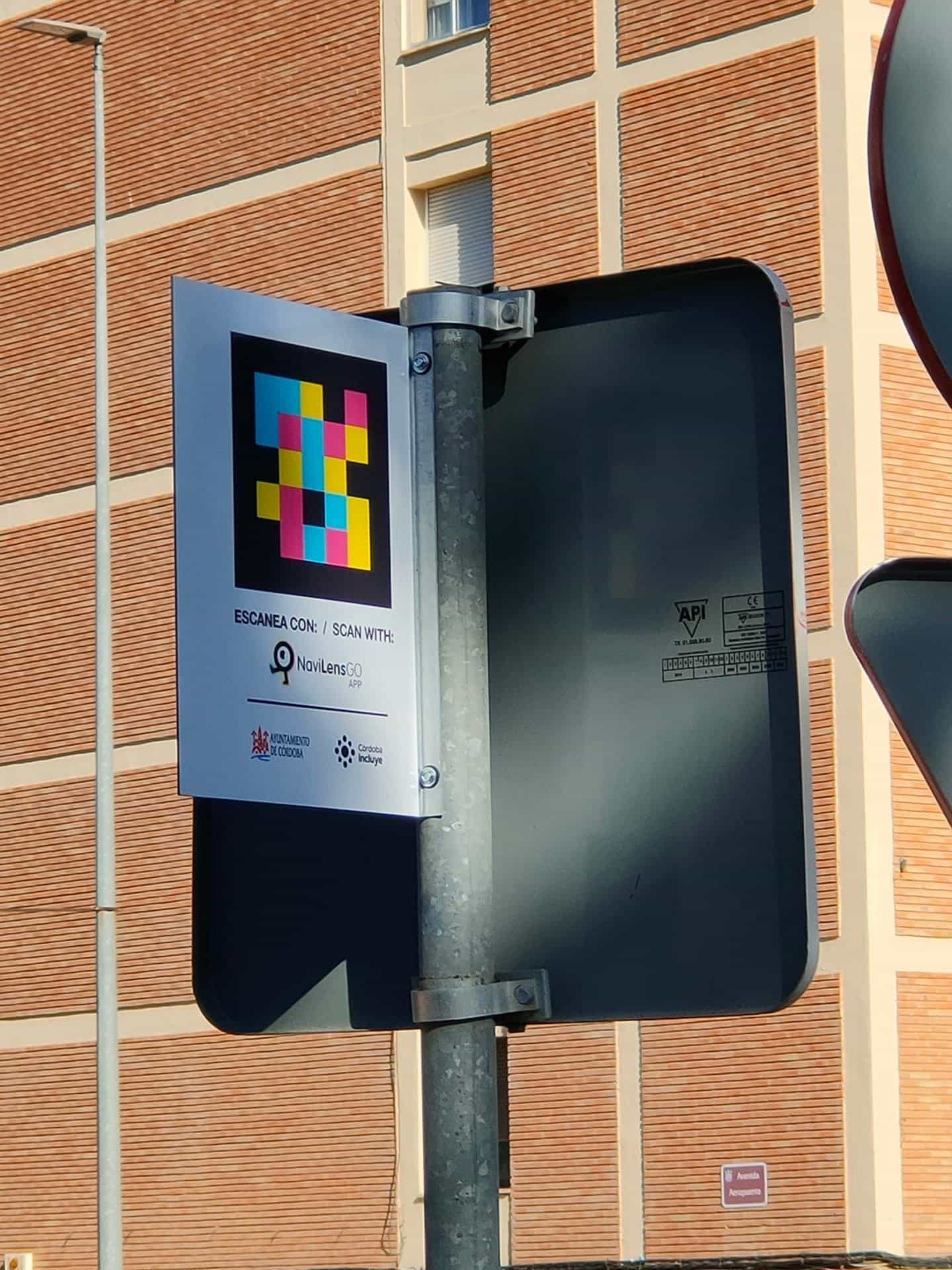 “Scan with NaviLens GO · Córdoba City Council · Córdoba Incluye” sign on the post of a taxi rank on Avenida Aeropuerto, Córdoba