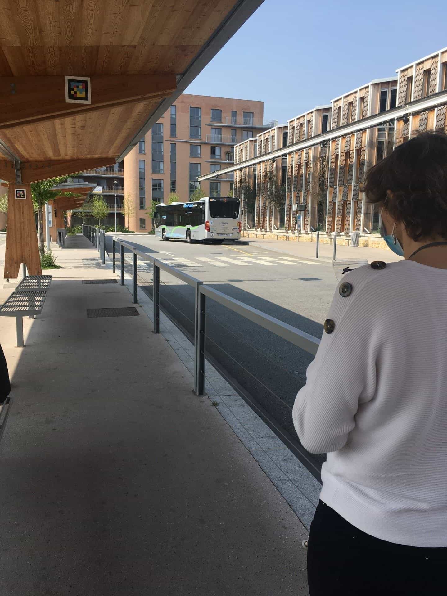 Bus stop at Versailles-Chantiers gare routière with NaviLens codes on the wooden canopy and a column.