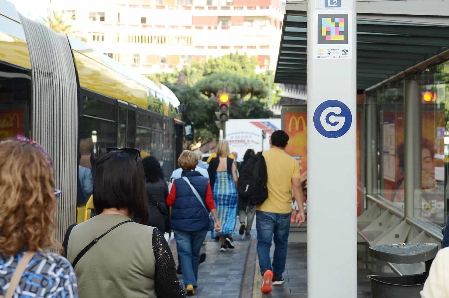 Pensilina della fermata L2 di Guaguas Municipales a Las Palmas de Gran Canaria con il codice NaviLens e la guagua gialla in avvicinamento