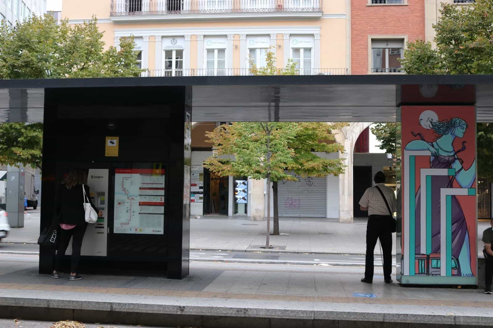Pensilina del tram di Saragozza in Plaza de España con biglietteria automatica, murale artistico mitologico e codice NaviLens