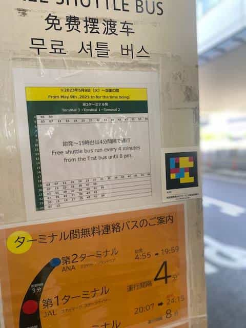 Outdoor shuttle bus stop with inter-terminal schedules and NaviLens code