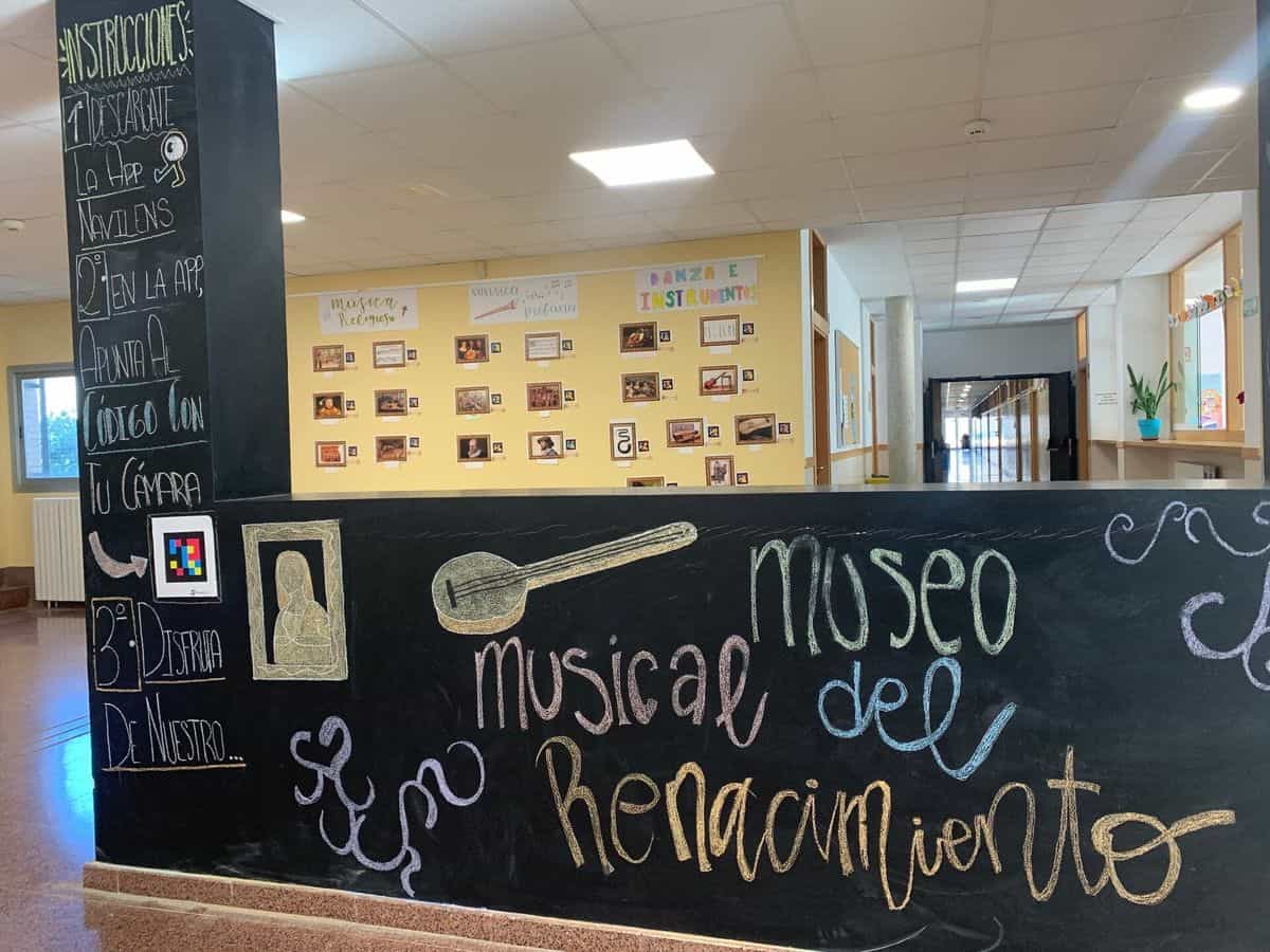 Blick auf den Eingang des Renaissance-Musikinstruments-Museums des IES Clara Campoamor Rodríguez in Zaragoza, mit der Kreidetafel, einem NaviLens-Code und den Tafeln für religiöse, weltliche und Tanzmusik im Hintergrund