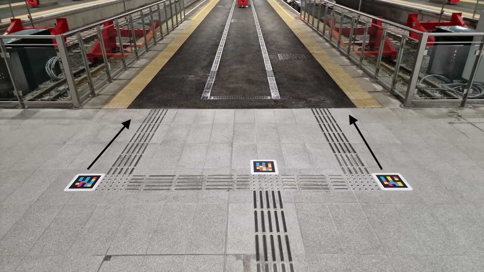 Drei NaviLens-Codes an einer taktilen Wegeleitung auf einem Bahnsteig des Belfast Grand Central Station
