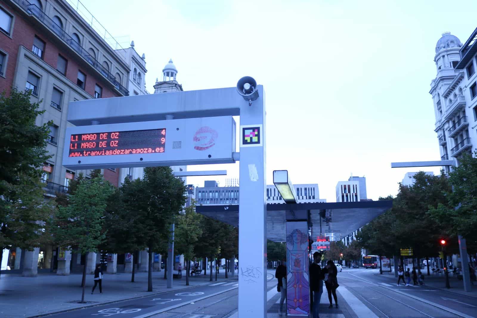Palina della fermata del tram di Saragozza con pannello led rosso dei prossimi passaggi e codice NaviLens applicato sul lato