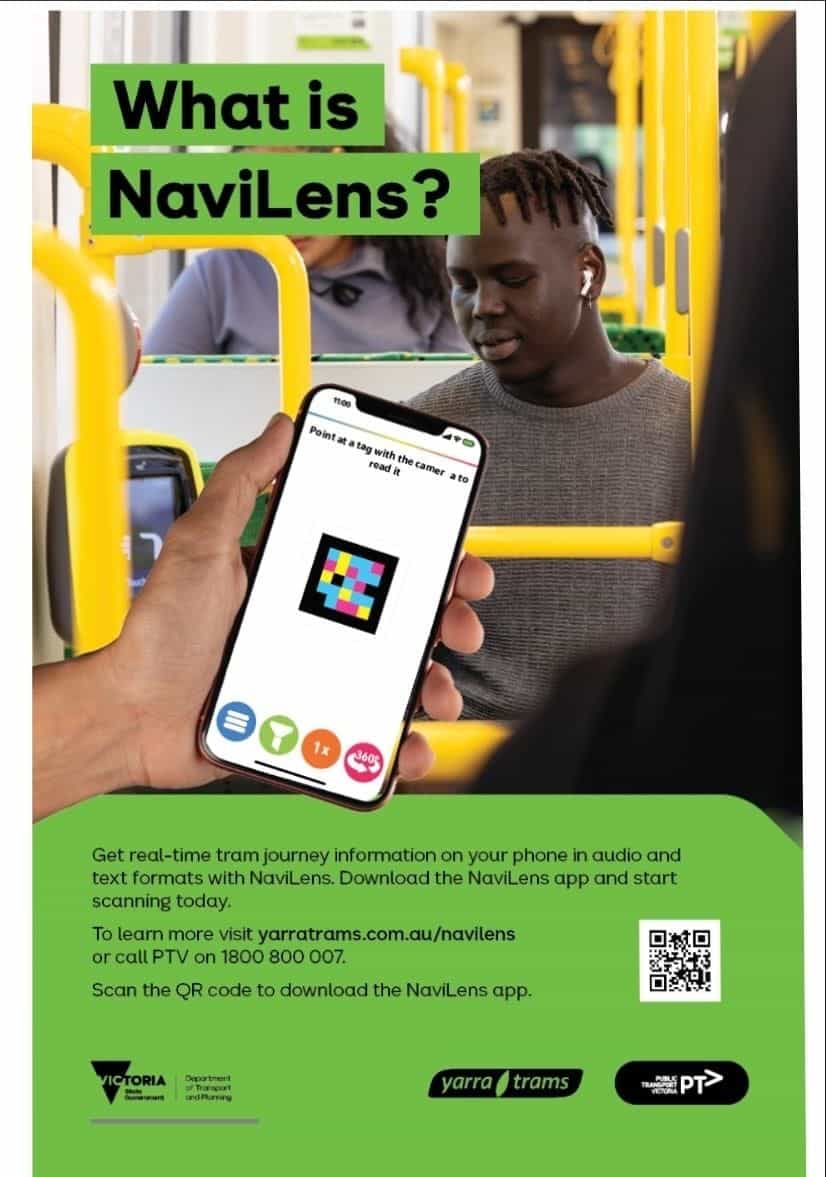 Cartel oficial verde y blanco titulado «What is NaviLens?» pegado en el interior de un tranvía amarillo de Yarra Trams, con la fotografía de un viajero joven con auriculares sosteniendo un móvil que escanea un código NaviLens; debajo, instrucciones para descargar la app, QR, teléfono PTV 1800 800 007 y los logos de Victoria State Government, Yarra Trams y Public Transport Victoria