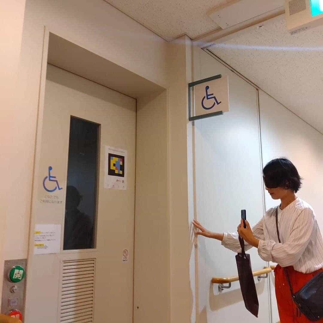 群馬県社会福祉総合センターのバリアフリートイレのドア、NaviLens 案内板と青の車いすマーク