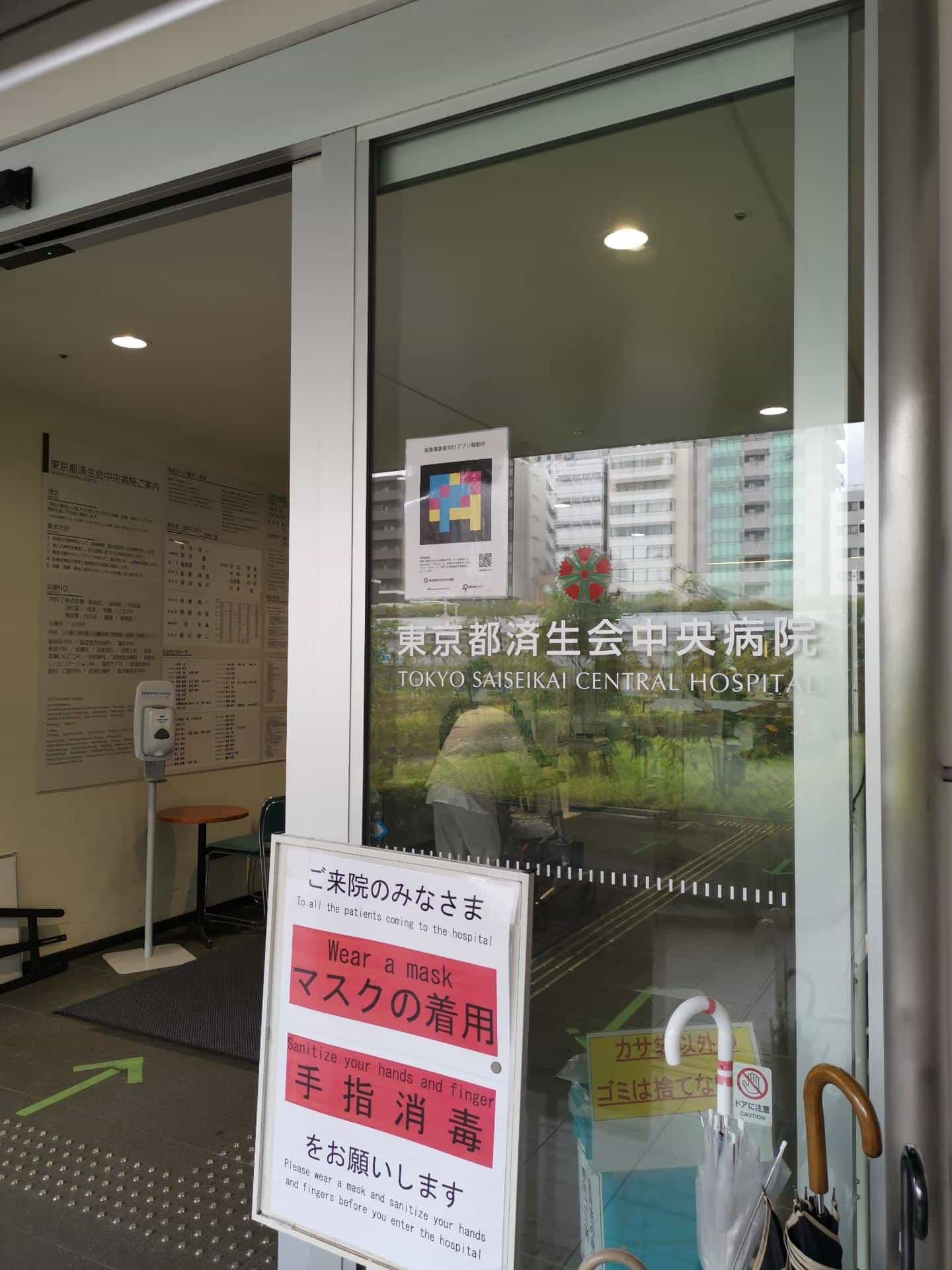 Glass door at Tokyo Saiseikai with a NaviLens marker and a person wearing a mask