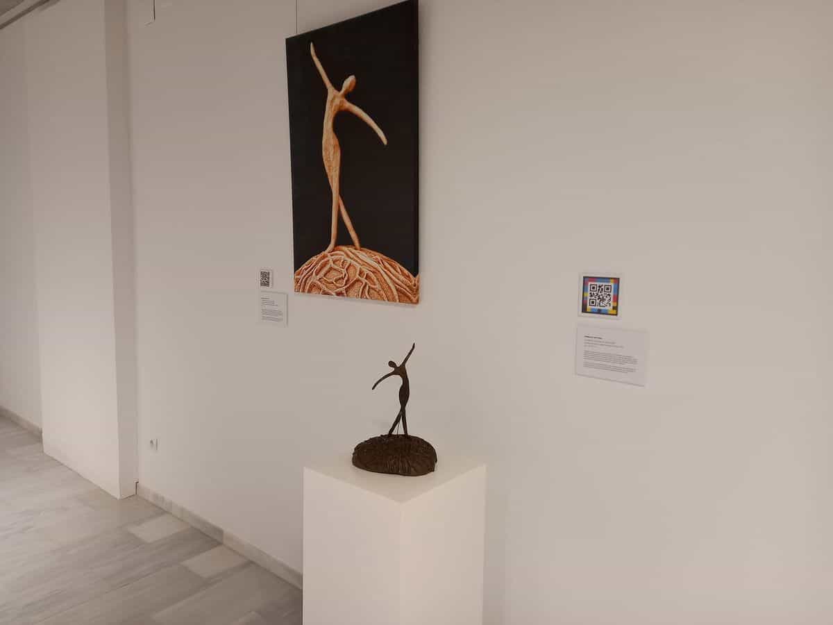 Saal des Centre d'Art GAB in Benissa mit Tänzerin-Skulptur, malerischer Reproduktion und NaviLens-Code am Schild