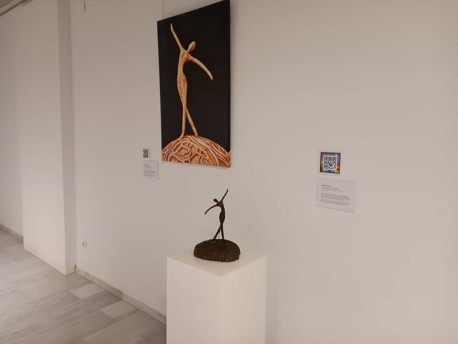 Saal des Centre d'Art GAB in Benissa mit Tänzerin-Skulptur, malerischer Reproduktion und NaviLens-Code am Schild