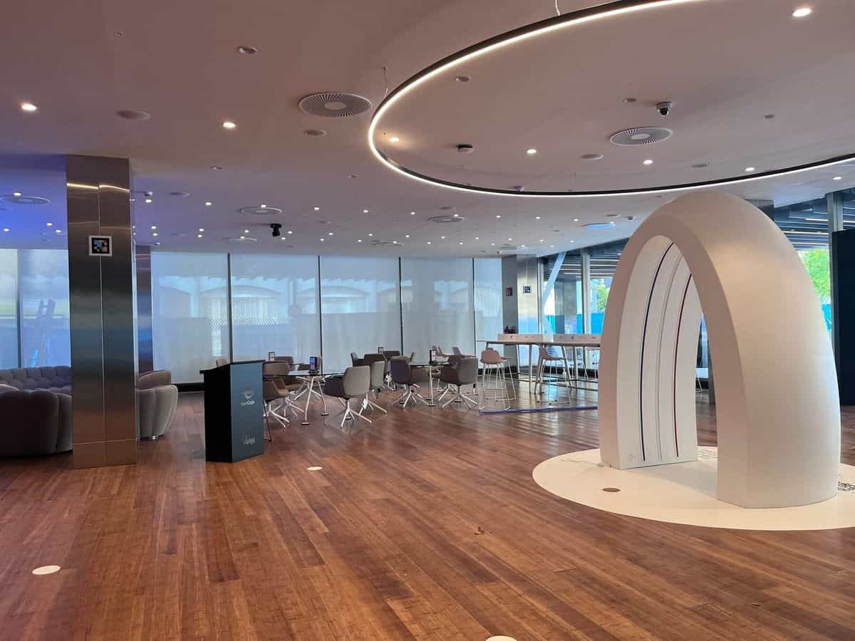Sala circular del Espacio Xplora con el arco blanco de la Zona Xperiencia y un código NaviLens en la columna de acero