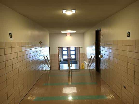 NIU interior hallway with emergency exit at the end and green guide strip on the floor, in one of the routes marked with NaviLens codes