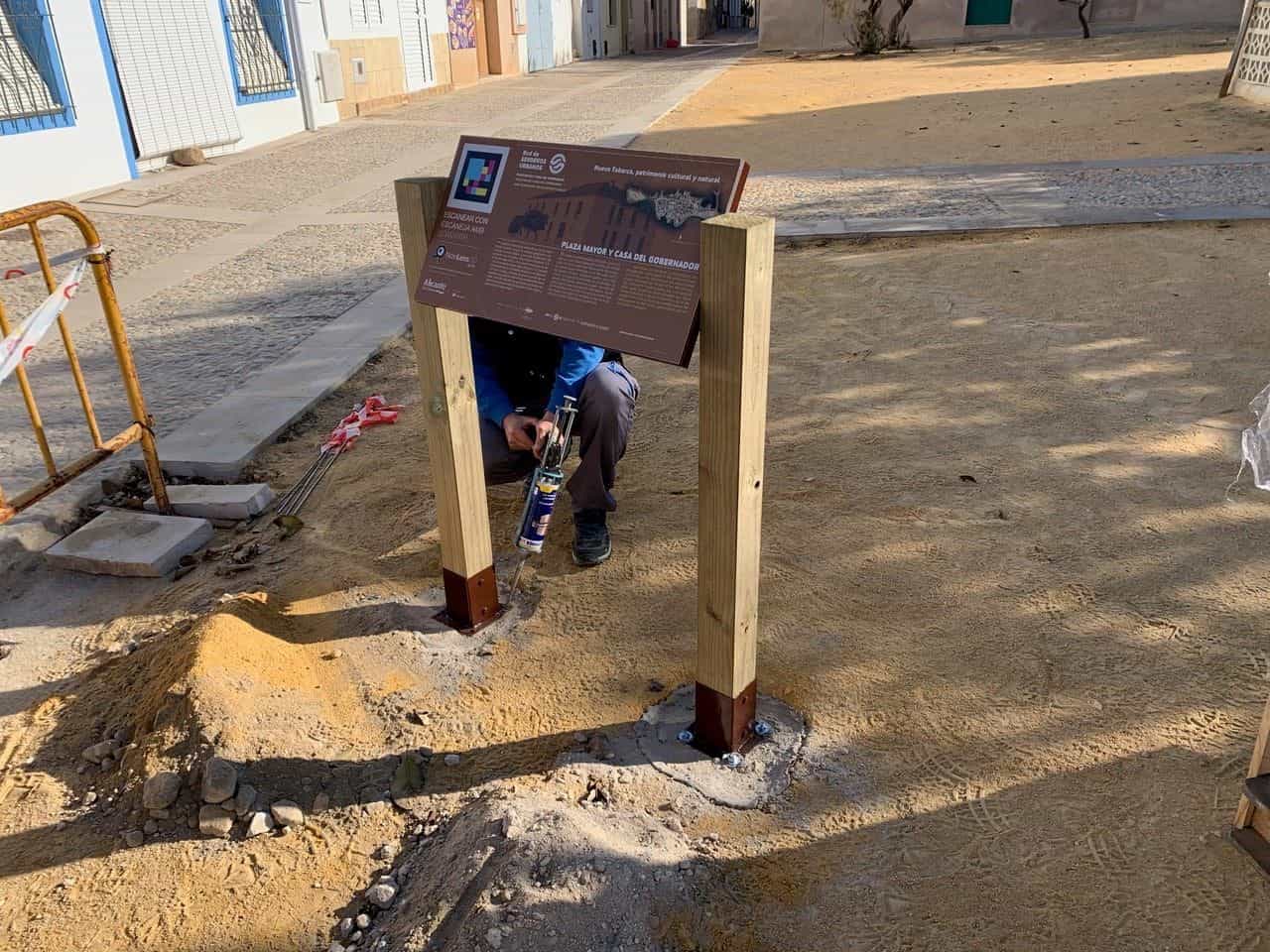 Arbeiter montiert die Tafel der Plaza Mayor und des Gouverneurshauses in Tabarca mit NaviLens-Code