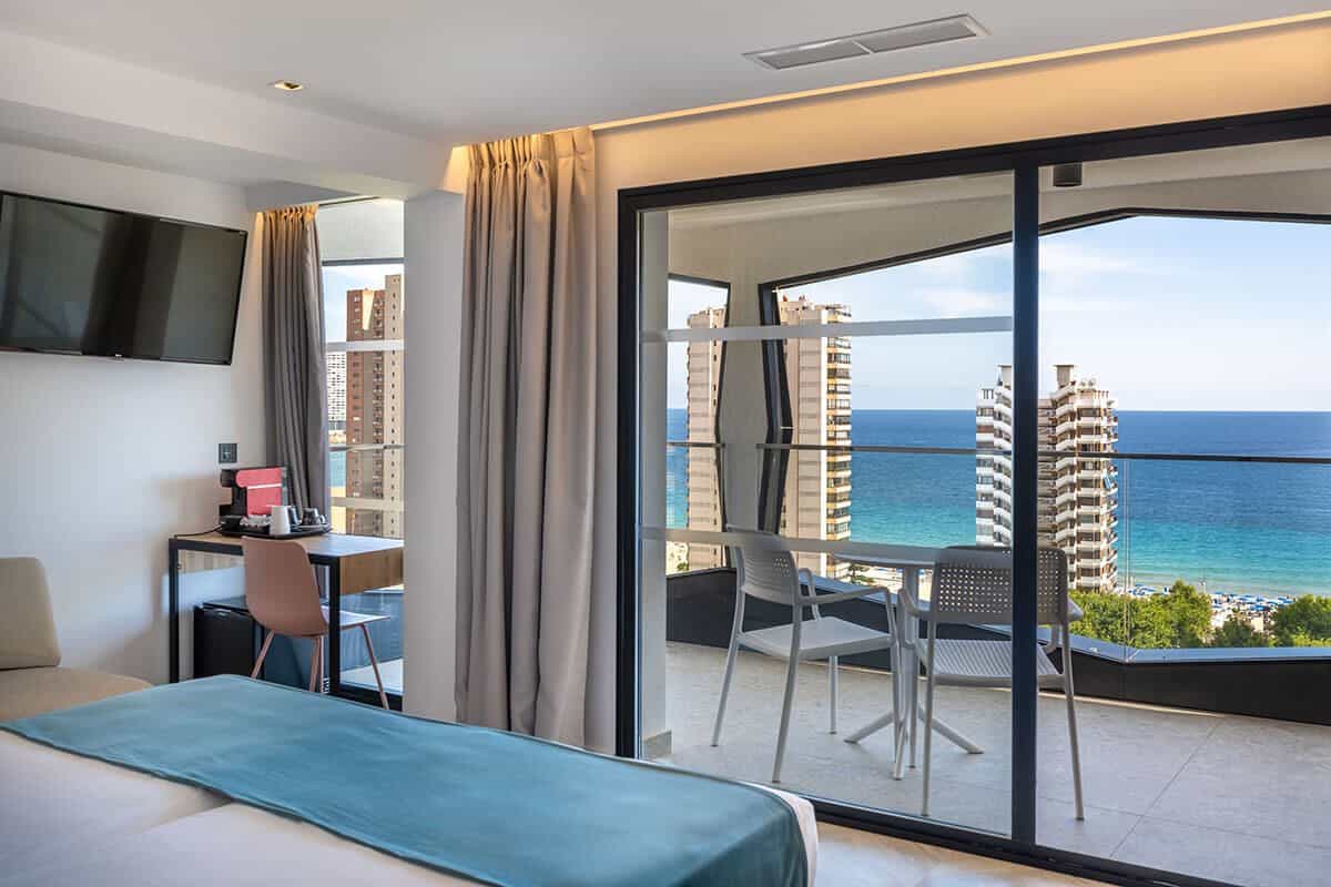 Private Terrasse eines Zimmers im Climia Belroy mit Tisch, Stühlen und Stadtblick auf das Zentrum von Benidorm