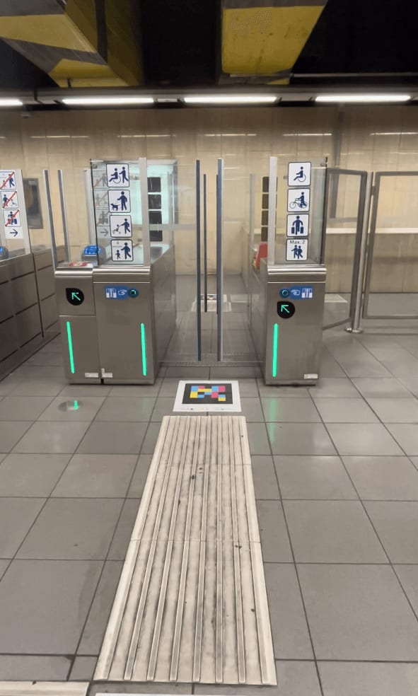 Barrierefreie STIB/MIVB-Tore in Brüssel mit NaviLens-Code auf dem Boden, in die taktile Linie eingebettet