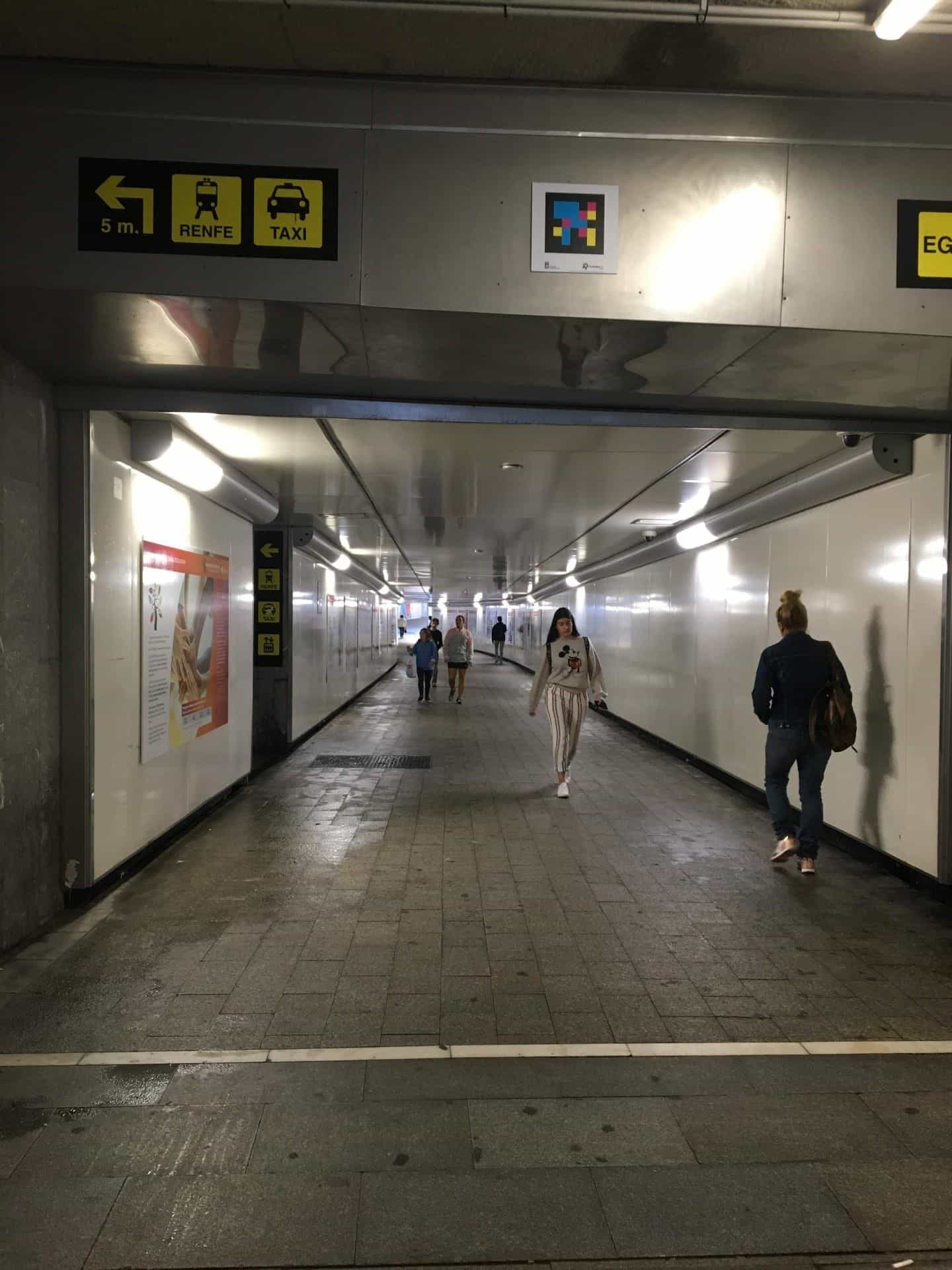 Tunnel di collegamento fra la stazione degli autobus e quella ferroviaria con cartello RENFE / TAXI e codice NaviLens