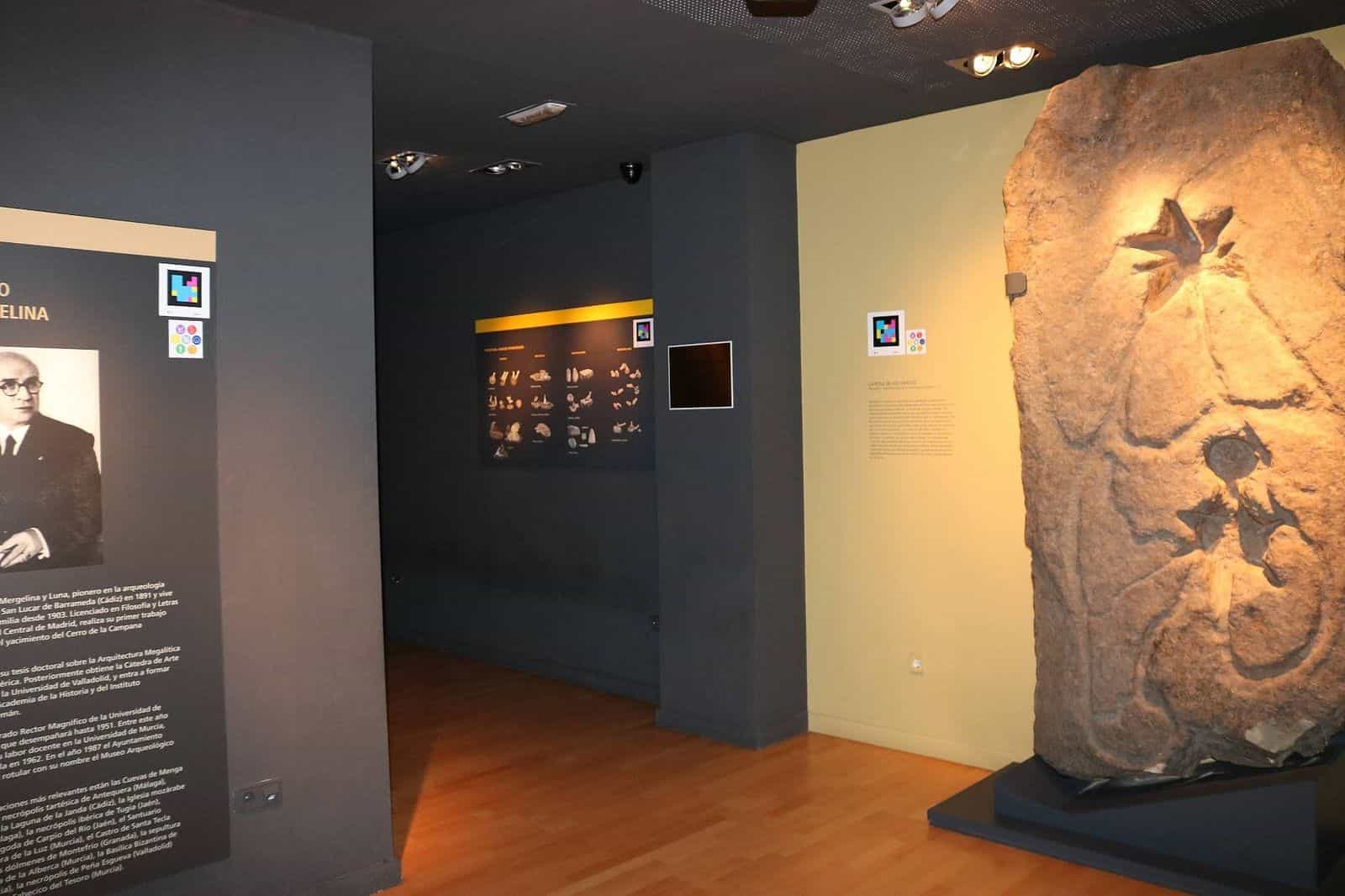Salle du Musée archéologique de Yecla avec codes NaviLens à côté de panneaux d’interprétation et d’une pièce archéologique monumentale