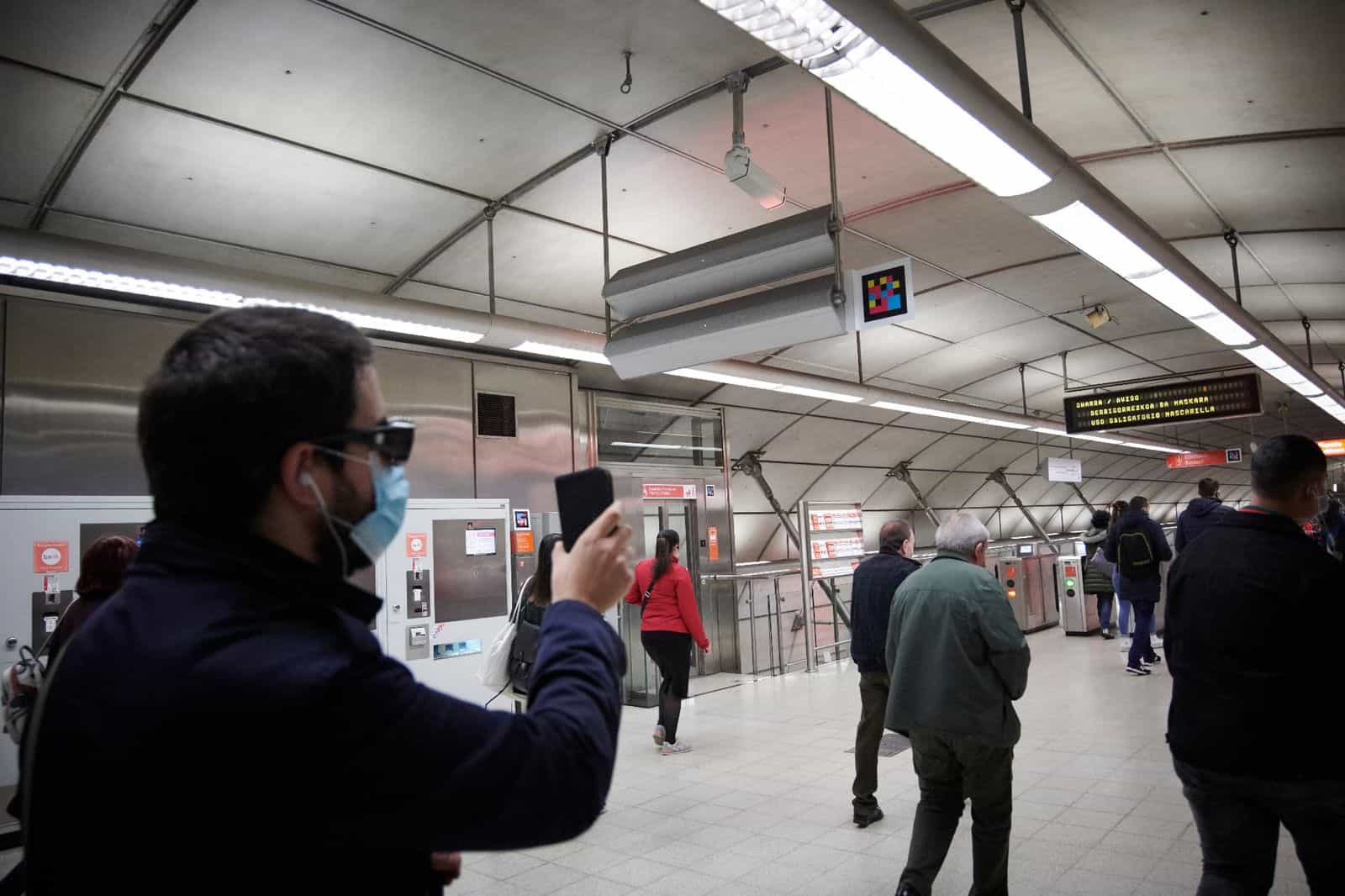 User pointing their phone at the NaviLens code in a Metro Bilbao concourse