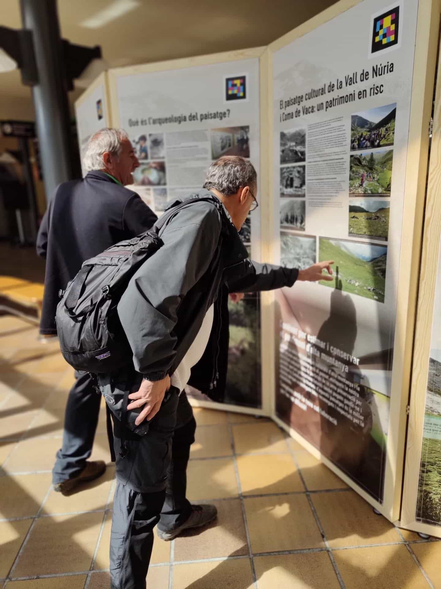 Due visitatori del centro di interpretazione della Vall de Núria che esplorano i pannelli del GIAP-ICAC