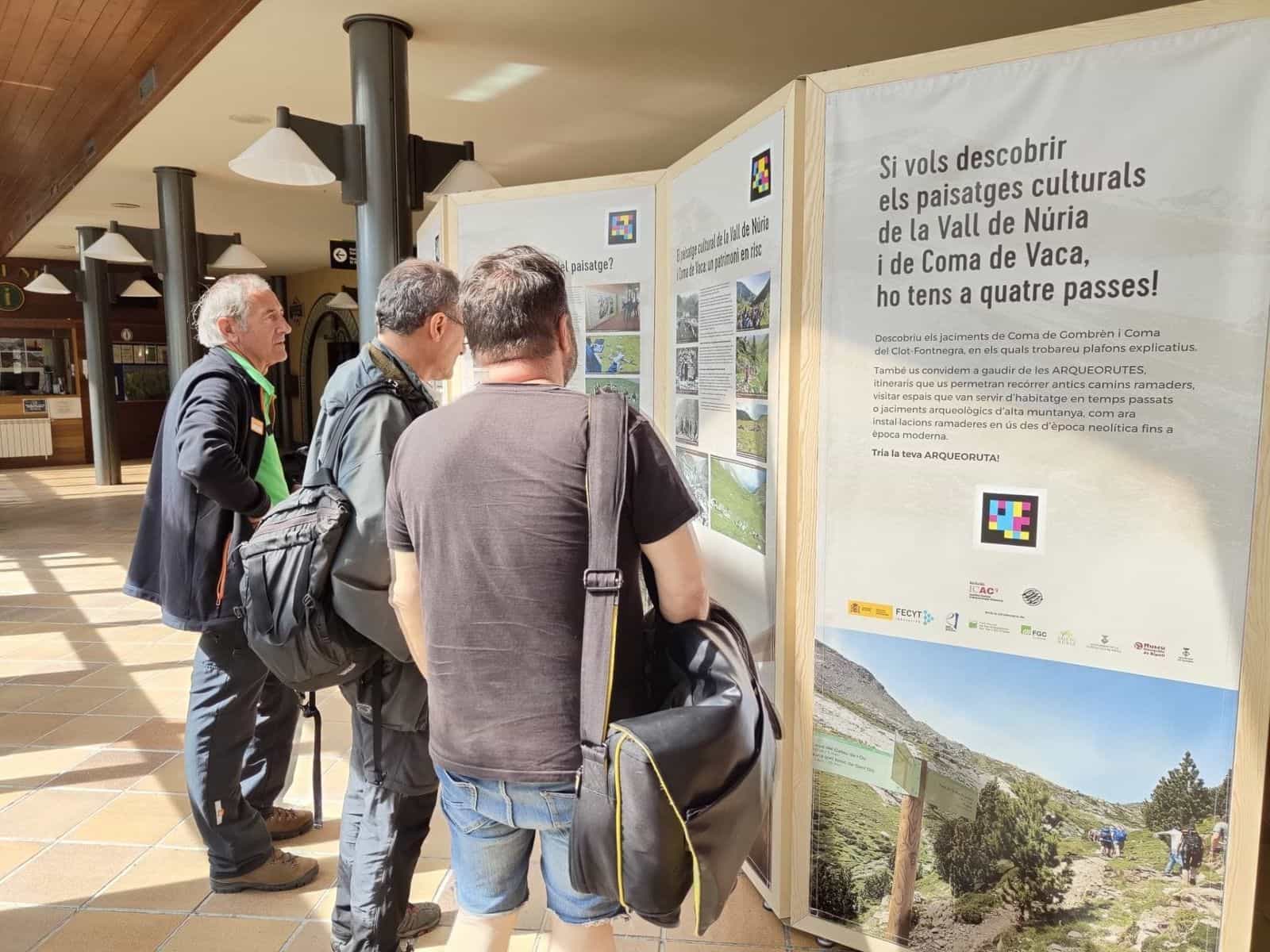 Tre visitatori che leggono il pannello finale con l’invito agli archeoitinerari e il codice NaviLens