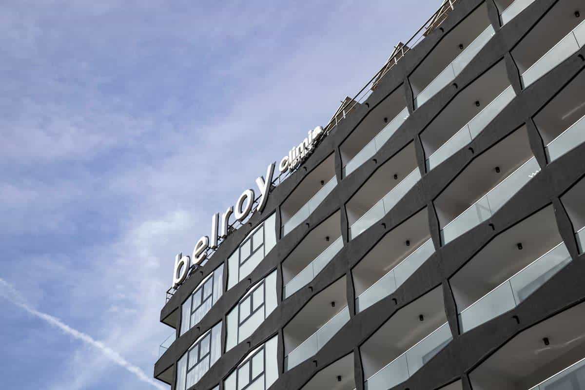 Aerial view of the Climia Belroy with the hotel façade and balconies over Avenida del Mediterráneo in Benidorm, surrounded by palm trees and the city